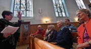 Karin Müller referiert über die Kirchenfenster. Auch Pfarrer Lukas Butscher und seine Frau Fiona (zweite Reihe) hören zu. (Bild: Manuel Nagel)