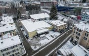 Das Gebäude der ehemaligen Migros-Filiale in Bruggen gehört nun der Stadt, ebenso das dahinter liegende Grundstück mit dem alten Schuppen. Für eine künftige Bebauung will die Stadt auch die rechts an die alte Migros angebaute Liegenschaft kaufen. (Bild: Hanspeter Schiess und Ralph Ribi)