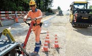 Polier Ralf Schüssling planiert den Strassenbelag. Das gute Wetter trägt dazu bei, dass die Arbeiten planmässig voranschreiten. (Bild: Helio Hickl)