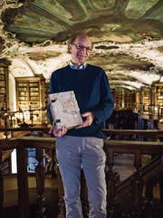 Karl Schmuki mit einer der Handschriften in der oberen Etage der Stiftsbibliothek. (Bild: Sabrina Stübi)