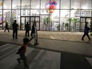 Passanten vor der Wanda Mall, einem Kaufhaus, das zur neu eröffneten Wanda Oriental Movie Metropolis in Qingdao, China, gehört - ein milliardenteurer Mega-Komplex, den Chinas reichster Mann Wang Jianlin finanziert hat. (Bild: Keystone/EPA/WU HONG)