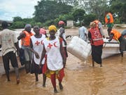 Rotkreuz-Helferinnen und -Helfer in Kenia mit Hilfsgütern für von Fluten betroffene Menschen (Bild: KEYSTONE/EPA/STR)