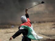 Ein Palästinenserin schleudert an der Gaza-Grenze zu Israel einen Stein. (Bild: KEYSTONE/AP/KHALIL HAMRA)