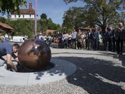 Die versiegelte Kupferkugel mit den Gedanken aus dem Bruder-Klaus-Gedenkjahr wird auf dem Dorfplatz von Flüeli in einen Schacht eingelassen. (Bild: Keystone/SIBYLLE KATHRINER FOTOGRAFIE)
