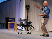Boston Dynamics-Chef Marc Raibert mit dem vierbeinigen Roboter, der bald auf den Markt kommen soll (Bild: KEYSTONE/AP/SHIZUO KAMBAYASHI)