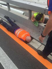 Voller Körpereinsatz: Die Polizisten der St.Galler Kantonspolizei bei der Rettung der Tiere auf der Autobahn. (Bild: Kapo SG)