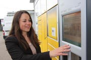 Postsprecherin Carmen Lama zeigt, wie der Paketautomat am Bahnhof Wil funktioniert. Post-Zugangspunkte wie dieser ersetzten Stück für Stück die herkömmliche Poststelle. (Bild: Simon Dudle)