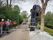 Die Feuerwehrleute versuchen das am Baum gelandete Auto sicher zu bergen. (Bild: PD)