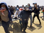 Während den blutigen Zusammenstössen im Gazastreifen an der Grenze zu Israel: Palästinensische Rettungskräfte und Protestierende transportieren einen schwerverletzten Jugendlichen auf einer Bahre. Der heutige Montag ist der Tag mit den meisten Todesopfern seit dem Gaza-Krieg 2014. (Bild: Keystone/AP/ADEL HANA)