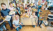 Die Klasse von Gaby Sager (kniend links) mit den gebastelten Gegenständen um Mattias Pult, auf dem Roboter Neo steht. (Bild: Reto Martin)