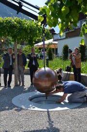 DIe Zeitkapsel auf dem Dorfplatz im Flüeli-Ranft wird vorsichtig in ihren zukünftigen Standort eingelassen. (Bild: Franziska Herger (Sachseln, 12. Mai 2018))