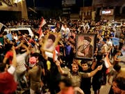 Anhänger schiitischen Predigers Moktada al-Sadr feiern auf den Strassen in Bagdad schon seinen Wahlsieg bei den Parlamentswahlen - obwohl das offizielle Endergebnis noch nicht feststeht. (Bild: KEYSTONE/AP/HADI MIZBAN)