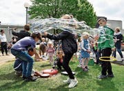 Die Kinder zaubern vor ihrem Schulhaus grosse Seifenblasen in die Luft. (Bild: Mario Testa)