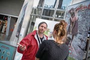 Roman Hagen von der Agentur Corris versucht, im Bahnhof Luzern eine Passantin zum Spenden zu animieren. (Bild: Pius Amrein (16. April 2018))