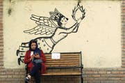 Eine Iranerin checkt ihr Smartphone; das Bild entstand Ende März in Teheran. (Bild: Abedin Taherkenareh/EPA)