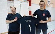Marcel Krüsi, Präsident des BSV Bischofszell, und Pascal Häderli, Verantwortlicher für die Öffentlichkeitsarbeit des BSV, präsentieren in der Sporthalle Bruggwiesen das Jubiläums-T-Shirt. (Bild: Georg Stelzner)