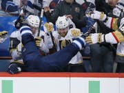 Winnipeg taucht im eigenen Stadion: Blake Wheeler landet nach einem Check von Ryan Reaves von den Vegas Golden Knights auf der gegnerischen Spielerbank (Bild: KEYSTONE/AP The Canadian Press/JOHN WOODS)