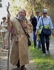 Wandermönch Angus bringt mit einer Pilgergruppe den St. Galler Klosterplan in die Stiftsbibliothek (Bild:P