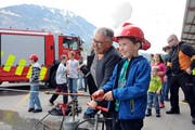 Gemeinderätin Doris Ming unterstützt einen Buben am Tag der Einsegnung des neuen Tanklöschfahrzeugs tatkräftig an der Handpumpe. (Bild Markus von Rotz, Giswil, 16. April 2016)