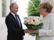 Blumen für den hohen Gast aus Deutschland: Russlands Präsident Putin empfängt Bundeskanzlerin Merkel in seiner Schwarzmeer-Residenz in Sotschi. (Bild: KEYSTONE/EPA SPUTNIK POOL/MICHAEL KLIMENTYEV / SPUTNIK / KREMLIN)