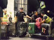 Polizisten verladen dutzende Kisten und Koffer voller Luxusartikel, die bei einer Razzia bei Malaysias Ex-Regierungschef Najib gefunden wurden. (Bild: KEYSTONE/AP)