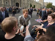 Prinz Harry begrüsst am Vorabend seiner Hochzeit bereits für das Fest versammelte Fans vor Schloss Windsor. (Bild: KEYSTONE/AP/PETER DEJONG)