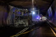Der ausgebrannte Reisecar im San Bernardino-Tunnel. Beim Feuer haben zwei Businsassen leichte Rauchgasvergiftungen erlitten. Der Tunnel bleibt vorläufig gesperrt. (KEYSTONE/Gian Ehrenzeller)