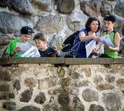 Marcel Bauer, Finn, Gabi und Leon Rufer absolvieren ausgerüstet mit Plan und Dachs den Detektiv-Trail vor dem Schloss Frauenfeld. (Bild: Reto Martin)