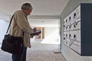 Ein Kontrolleur der Billag AG vergleicht die Namen auf den Klingelschildern mit den Billag-Zahlern auf seiner Liste. Bild: Keystone