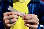 Ein Jugendlicher dreht sich einen Joint. Bild: Keystone