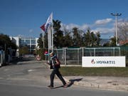 Ein Mann überquert vor der Novartis-Niederlassung in Athen eine Strasse. Dem Basler Pharmakonzern wird vorgeworfen, in Griechenland Ärzte und Politiker bestochen zu haben. (Bild: Keystone/AP/PETROS GIANNAKOURIS)
