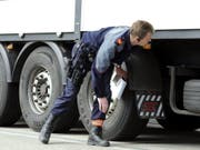 Ein Polizist kontrolliert einen Lastwagen anlässlich einer Car- und Schwerverkehrskontrolle der Kantonspolizei Zürich. (Bild: Keystone/WALTER BIERI)