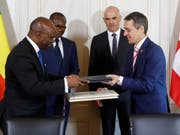 Aussenminister Ignazio Cassis (vorne rechts) und sein beninischer Amtskollege Aurélien Agbénonci bei der Unterzeichnung eines Projektabkommens. Hinten Benins Präsident Patrice Talon (links) und Bundespräsident Alain Berset. (Bild: Keystone/PETER KLAUNZER)