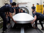 Das Entwicklungsteam von Swissloop mit dem neuen Prototypen "Mujinga" von Swissloop. In Zukunft sollen Transportkapseln Güter schneller und umweltschonender von A nach B befördern. (Bild: KEYSTONE/PATRICK HUERLIMANN)