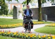 Vorbildlich: Der Zuger CVP-Stadtrat Urs Raschle setzte sich nach der Präsentation einen Helm auf und schnappte sich kurzerhand eines der zehn elektrounterstützten Cargo-Bikes für eine erste Probefahrt. Foto: Zuger Zeitung/Stefan Kaiser