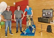 René Bernegg und Simon Berner, Kolb Elektro AG, lassen Roger Eppich, Abwart des Schulhauses Haag, auf dem Velo spüren, dass LED-Lampen weniger Energie brauchen als die konventionellen Glühlampen. (Bild: Heidy Beyeler)