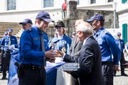 Polizist Dominik Ettlin erhält nach der Vereidigung in Sursee von Polizeiseelsorger Robert Knüsel ein Teelicht. (Bild: Manuela Jans-Koch, 24. Mai 2018)