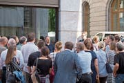 Erich Leutwyler (im blauen Shirt) mit Interessierten vor dem neuen Gebäude. Rechts zu sehen ist die alte Post. (Bild: Maria Schmid (24. Mai 2018))