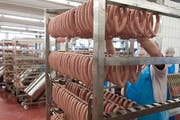 Gestelle werden mit Wienerli aufgefüllt beim Fleischverarbeiter Bell in Basel am Montag, 16. Februar 2015. (Bild: Georgios Kefalas/Keystone)
