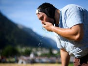 Daniel Bösch erfrischt sich hier am Glarner-Bündner Fest vom Pfingstmontag (Bild: KEYSTONE/GIAN EHRENZELLER)