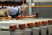 Ein Mitarbeiter überprüft eine Maschine in einer Textildruckerei. Bild: Christian Beutler/Keystone (15. Juli 2014)