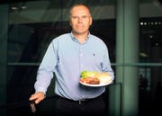Der niederländische Physiologie-Professor Mark Post präsentiert seinen gezüchteten Rindfleischburger. (Bild: Simon Dawson/Bloomberg (London, 6. August 2013))