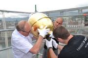 Oskar Näpflin (links) mit weiteren Mitarbeitern der Firma Muff Kirchturmtechnik AG Triengen beim Befestigen der Goldkugel auf der Kirchturmspitze. Bild :Hugo Bischof (Luzern, 29. Mai 2018)