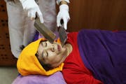 Eine ungewöhnliche Massage: Mit Messern sollen Energien ins Gleichgewicht gebracht werden. Bild: Ritchie B. Tongo/EPA (Taipeh, 17. April 2018)