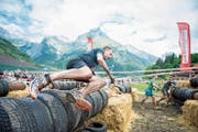 Ein Strongmanrun-Teilnehmer springt über die Reifenmauer. Bild: Roger Grütter (Engelberg, 3. Juni 2017)