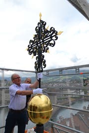Oskar Näpflin befestigt die Goldkugel mit Kreuz definitiv auf der Spitze des Kirchturms der Peterskapelle. Bild: Hugo Bischof (Luzern, 29. Mai 2018)