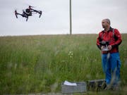 Ausserrhoder Jäger und Landwirte gehen neue Wege in der Rehkitzrettung: Drohnenpilot Ueli Sager lässt seinen Multikopter über eine Wiese in Rehetobel fliegen. Rehkitze, die sich im hohen Gras verstecken, sollen dank der Wärmebildkamera vor dem Mähen aufgespürt werden. (Bild: KEYSTONE/GIAN EHRENZELLER)