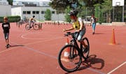 Der Sechstklässler übergibt den Tennisball aus der einen Hand in die andere und legt ihn auf den Leitkegel. (Bild: Carmen Kaufmann)