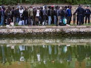 Flüchtlinge stehen Schlange, um in Unterkünfte in Paris oder der Umgebung gebracht zu werden. Seit Monaten hatten sich immer mehr Migranten an den Ufern zweier Kanäle im Nordosten der französischen Hauptstadt angesiedelt. (Bild: Keystone/EPA/IAN LANGSDON)