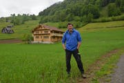 Köbi Knaus steht auf der Wiese vor dem Wohnhaus der Familie, auf der Winterweizen wächst. (Bild: Christiana Sutter)